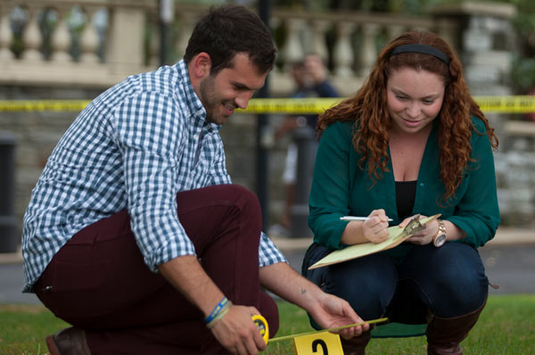 Forensic Medicine students take notes at mock crime scene