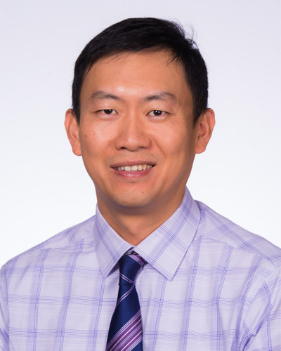 Professional headshot photograph of Xinyu (Eric) Wang, PhD, wearing a shirt and tie