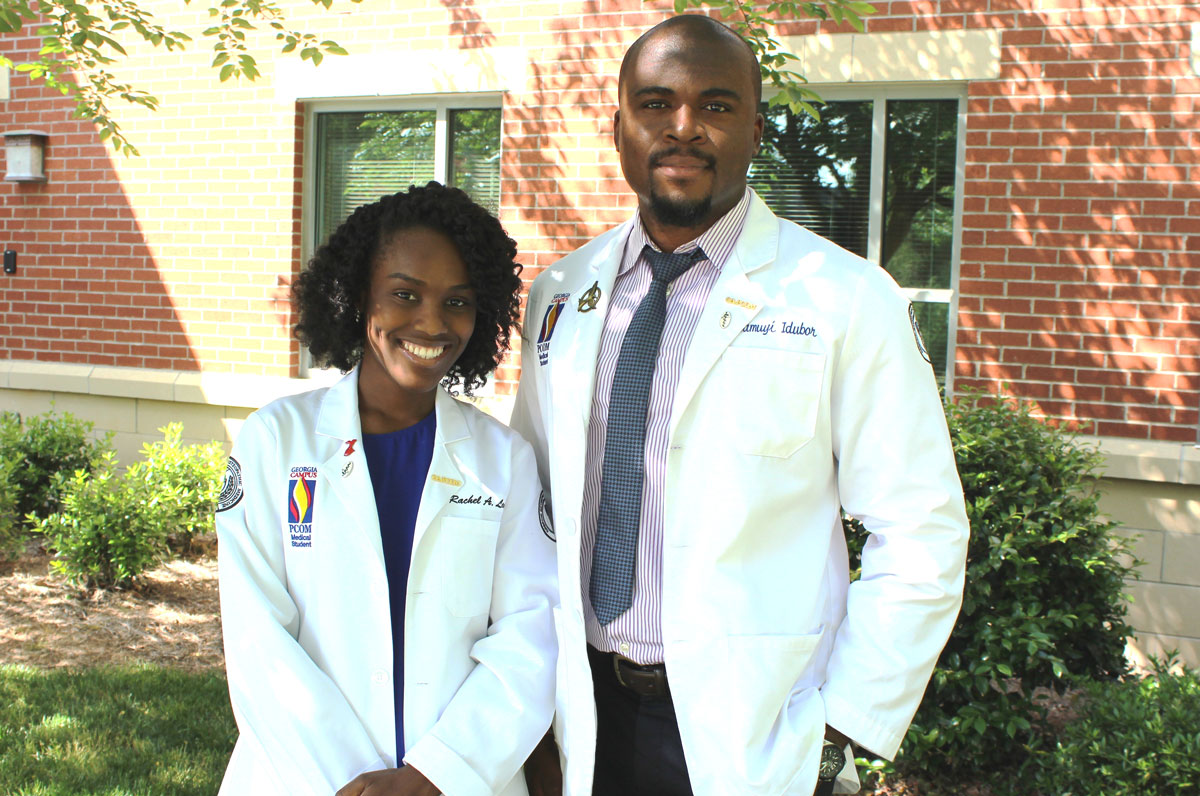 Osteopathic medical students pose in their white coats outside of PCOM Georgia's campus building