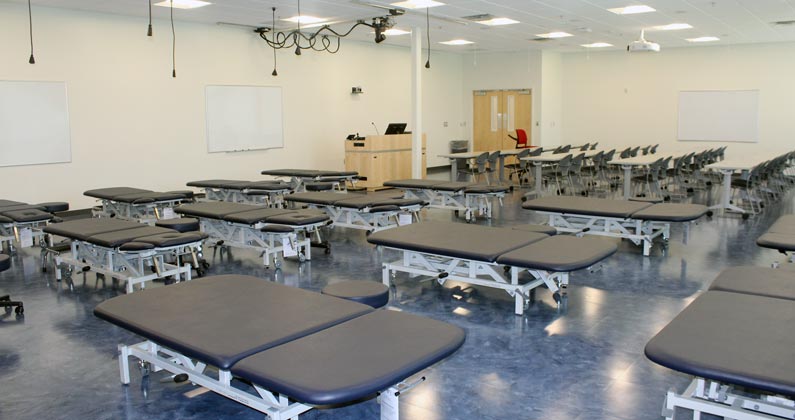 Physical therapy classroom at GA-PCOM with examination tables and educational equipment