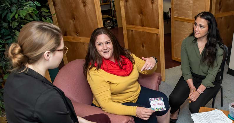 Lisa Corbin, assistant professor, counseling, works with two counseling students in a study room