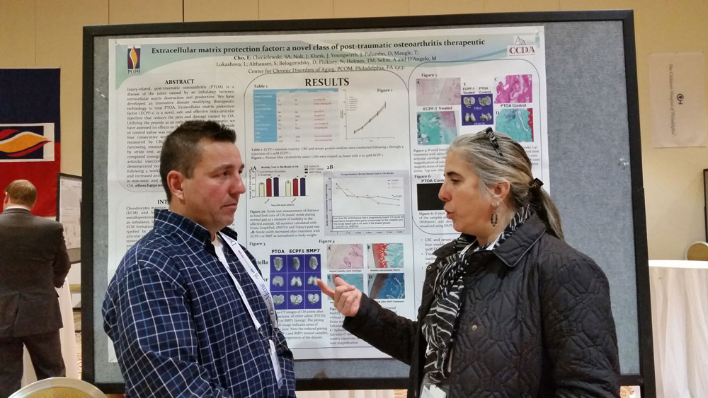 PCOM biomedical sciences faculty Marina D’Angelo, PhD, speaks in front of her research poster
