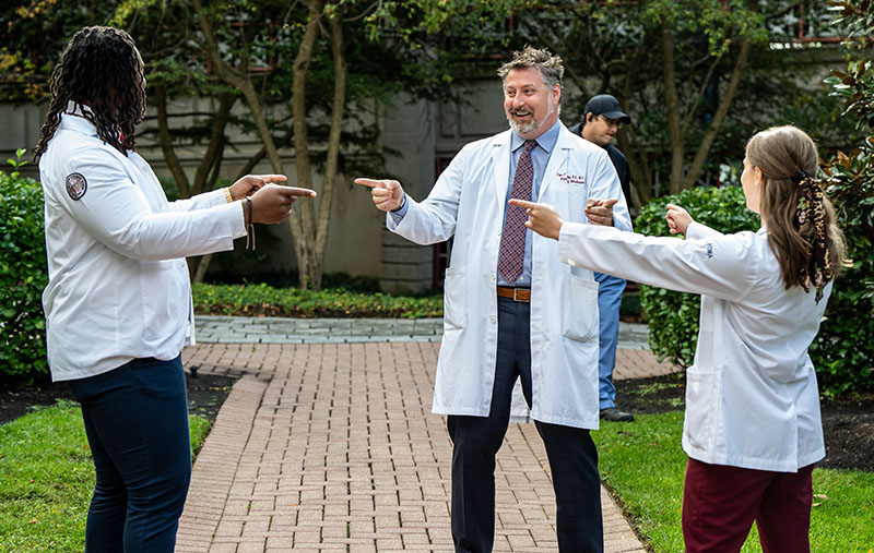 Dr. Bidey and two DO students recreate the Spider-Man pointing meme, 2023.