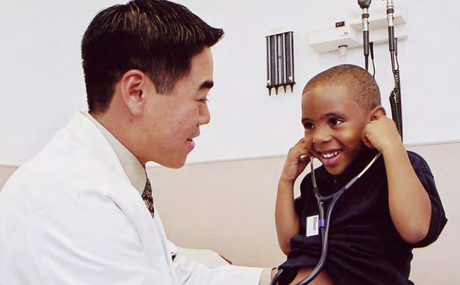 Primary care physician David Kuo (DO '96) in 2001 with a young patient. Dr. Kuo is now Associate Dean of Graduate Medical Education and Associate Professor of Family Medicine.