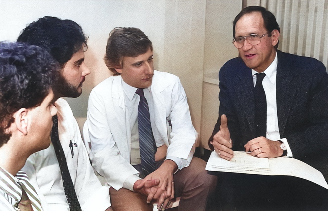 DO students David Hassman and Dominick Zampino, from left, discuss patient evaluations with Dr. Freeman and Dr. Berger (1991).