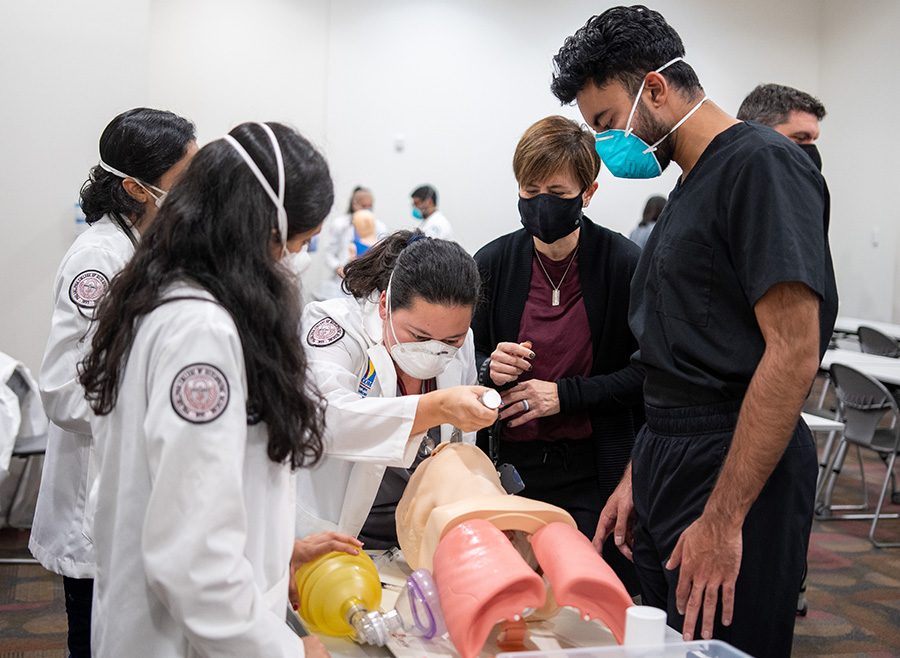 Andrea Mann, DO, dean and chief academic officer of PCOM Georgia's DO program, works with med students on an airways exercise in 2021.