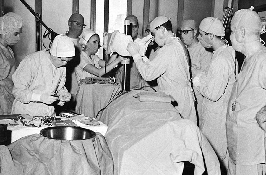 PCOM faculty and students prepare for microsurgery on a patient's ear in 1967. Alvin D. Dubin, DO '56, is at the microscope.