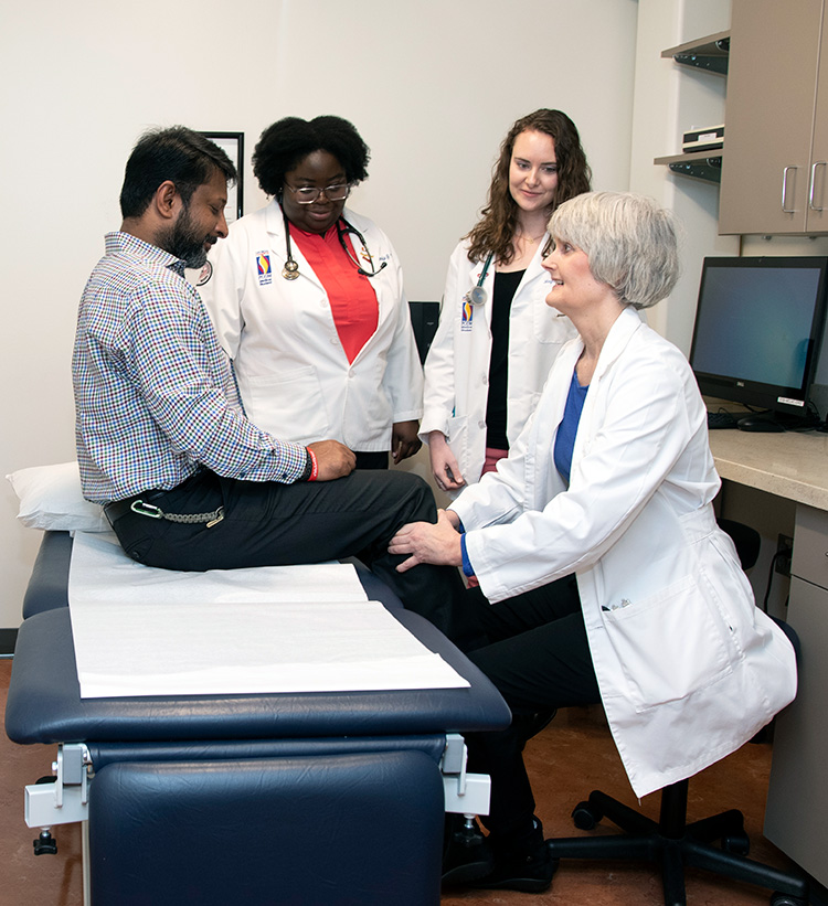 Shawne Murray, DO, examines a patient with two medical students in one of the exam rooms (2019).