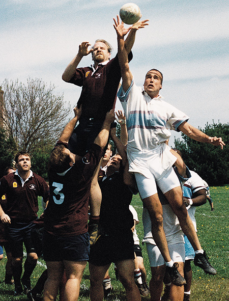 Matthew Lawrence, DO '98, (white jersey) reaches for the ball during a rugby match in the late 90s.