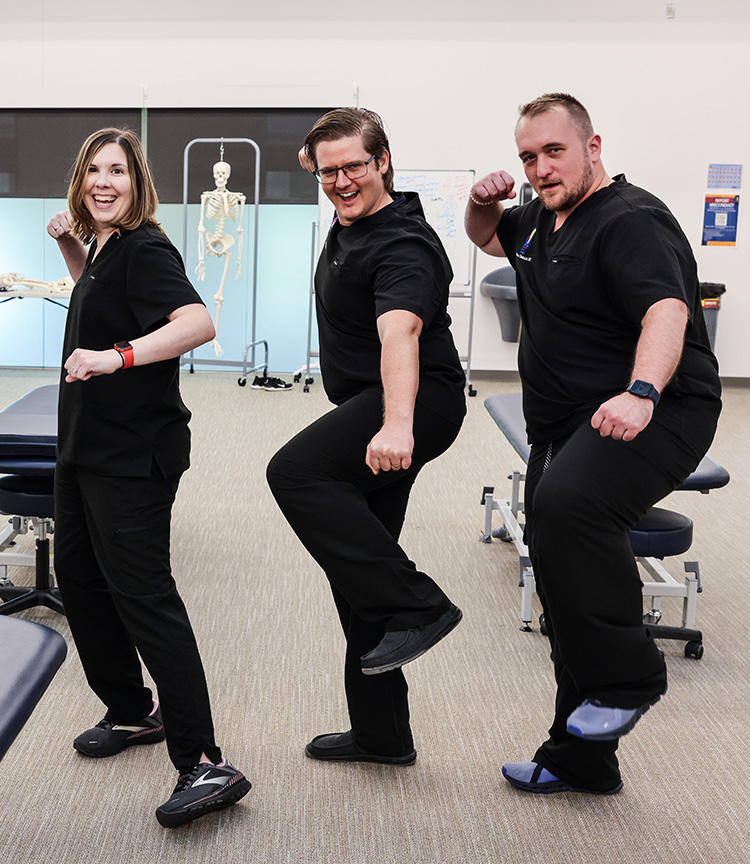 Kristie Petree, DO '13, and other PCOM South Georgia OMM faculty laugh as they strike poses during a photography shoot (2023).