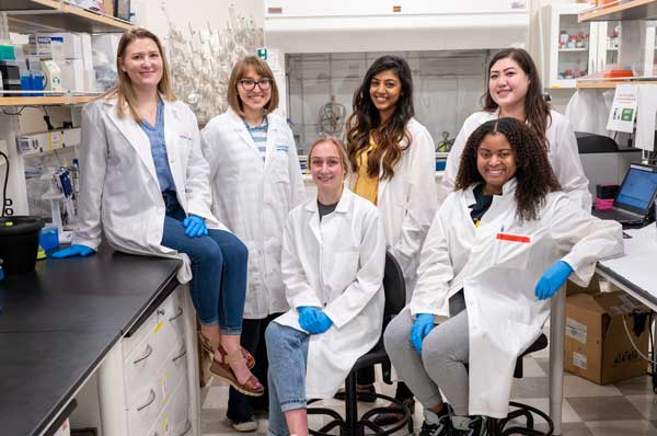 Biomedical science students in lab coats are shown inside the biomedical sciences lab at PCOM Georgia.