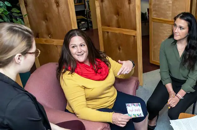 Lisa Corbin, PhD, LPC, NCC talks with two females.