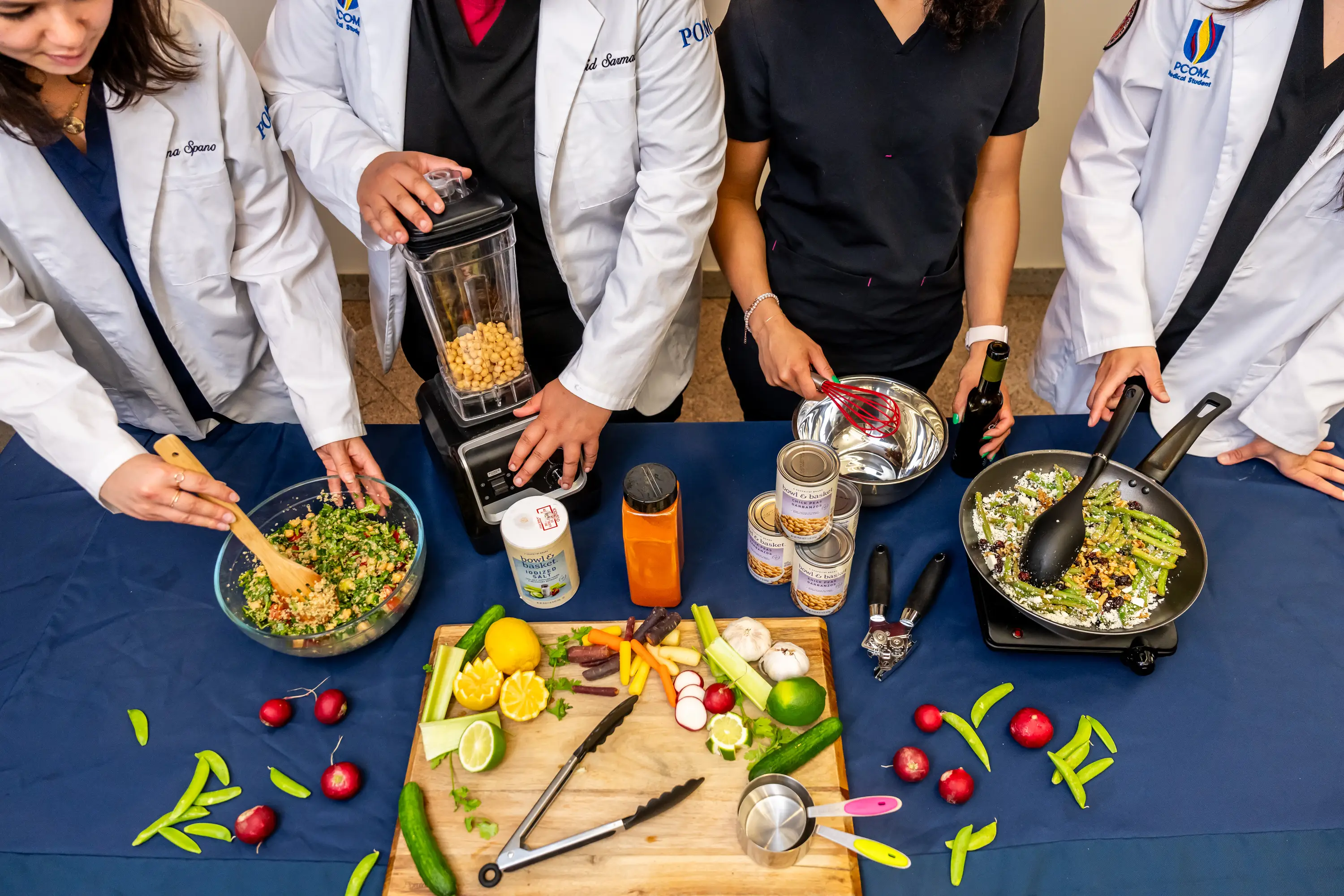 Four students work together to cook a meal.