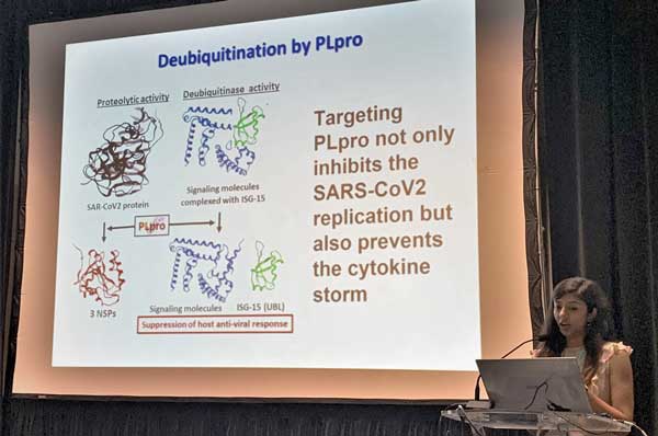 A PCOM School of Pharmacy student is shown at a podium on stage presenting her research at the SERMACS 2022 meeting in Puerto Rico.