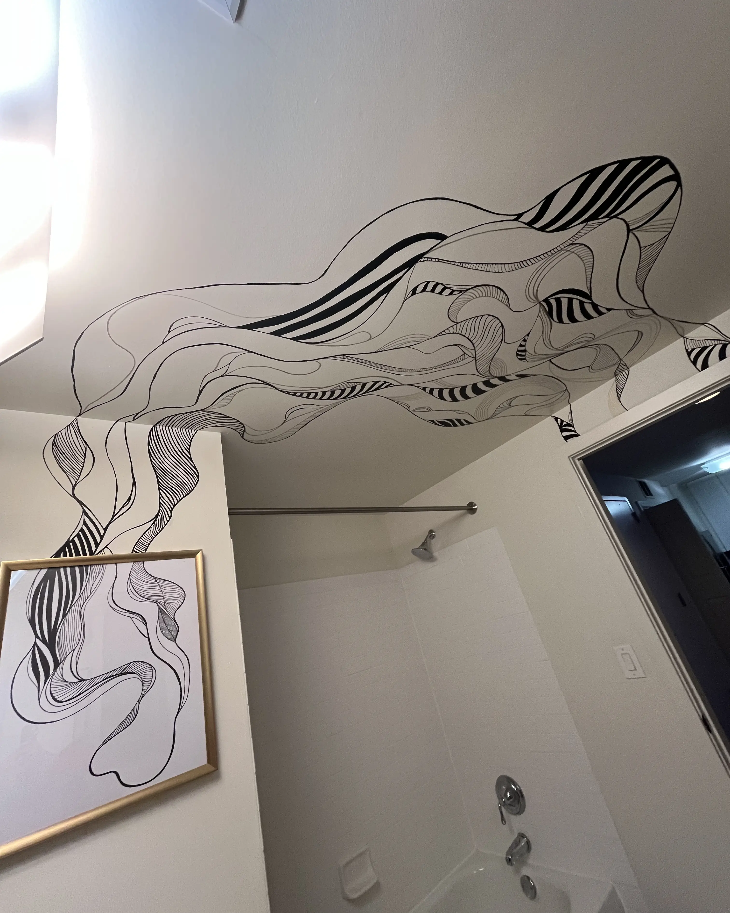 A black and white geomateric pattern painted on a ceiling and wall