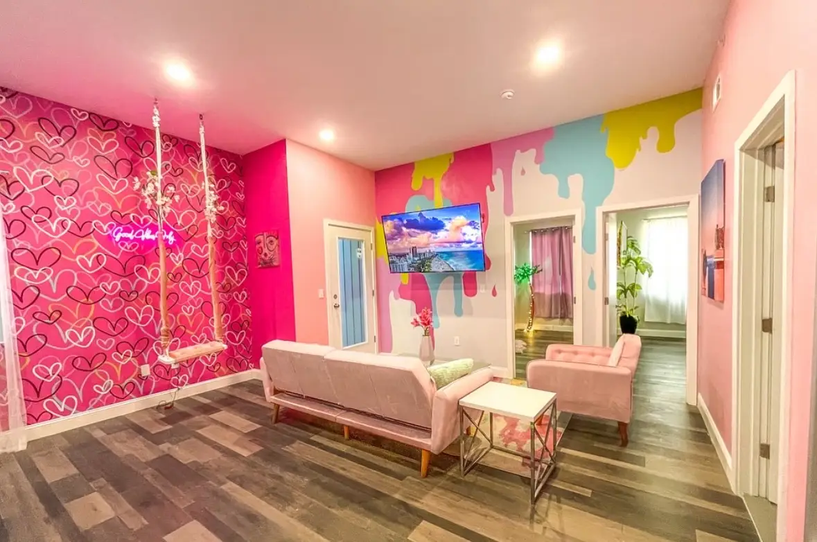 A colorful pink room painted with various shapes and patterns.