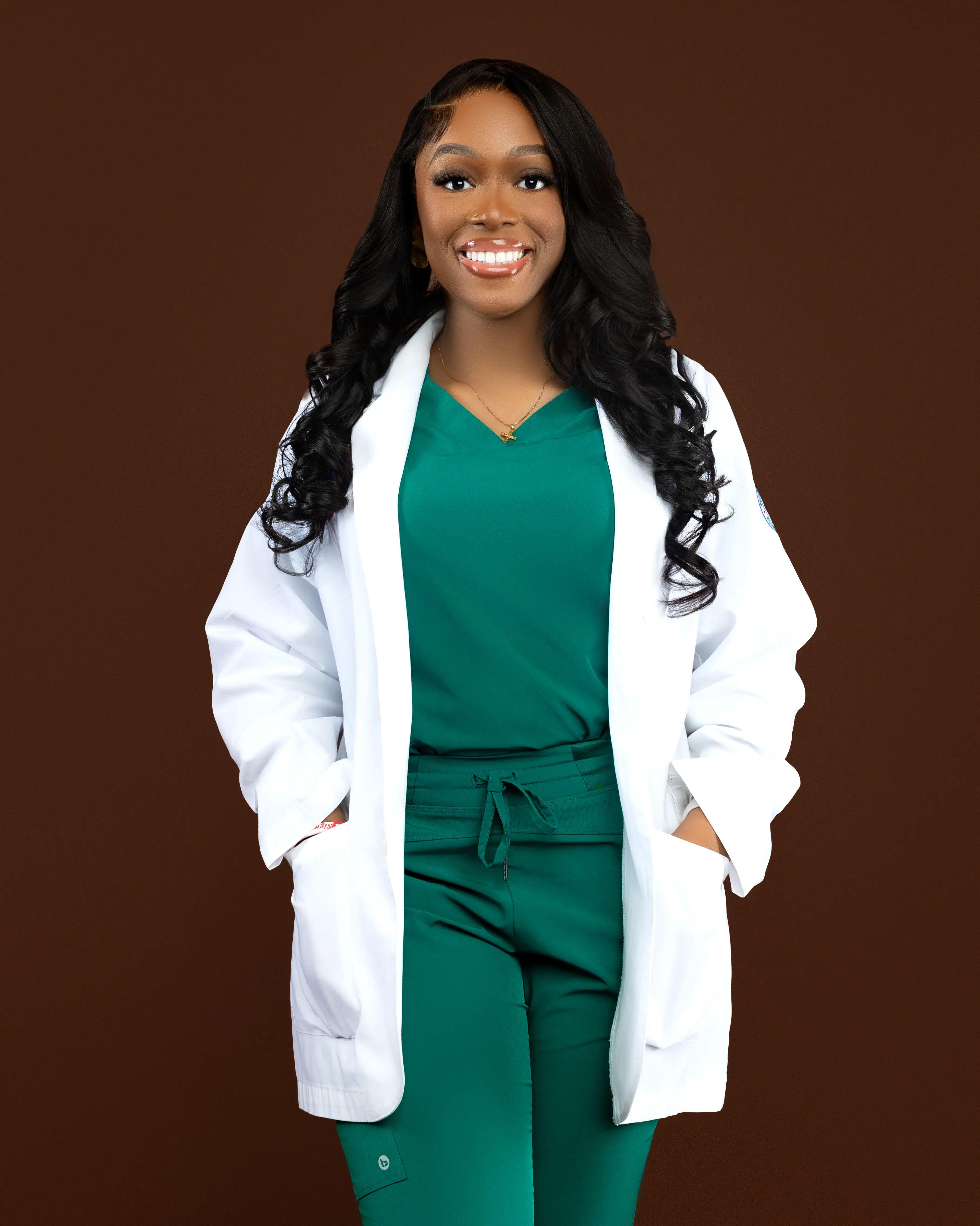 Dr. Emeka wearing green scrubs and a white coat.