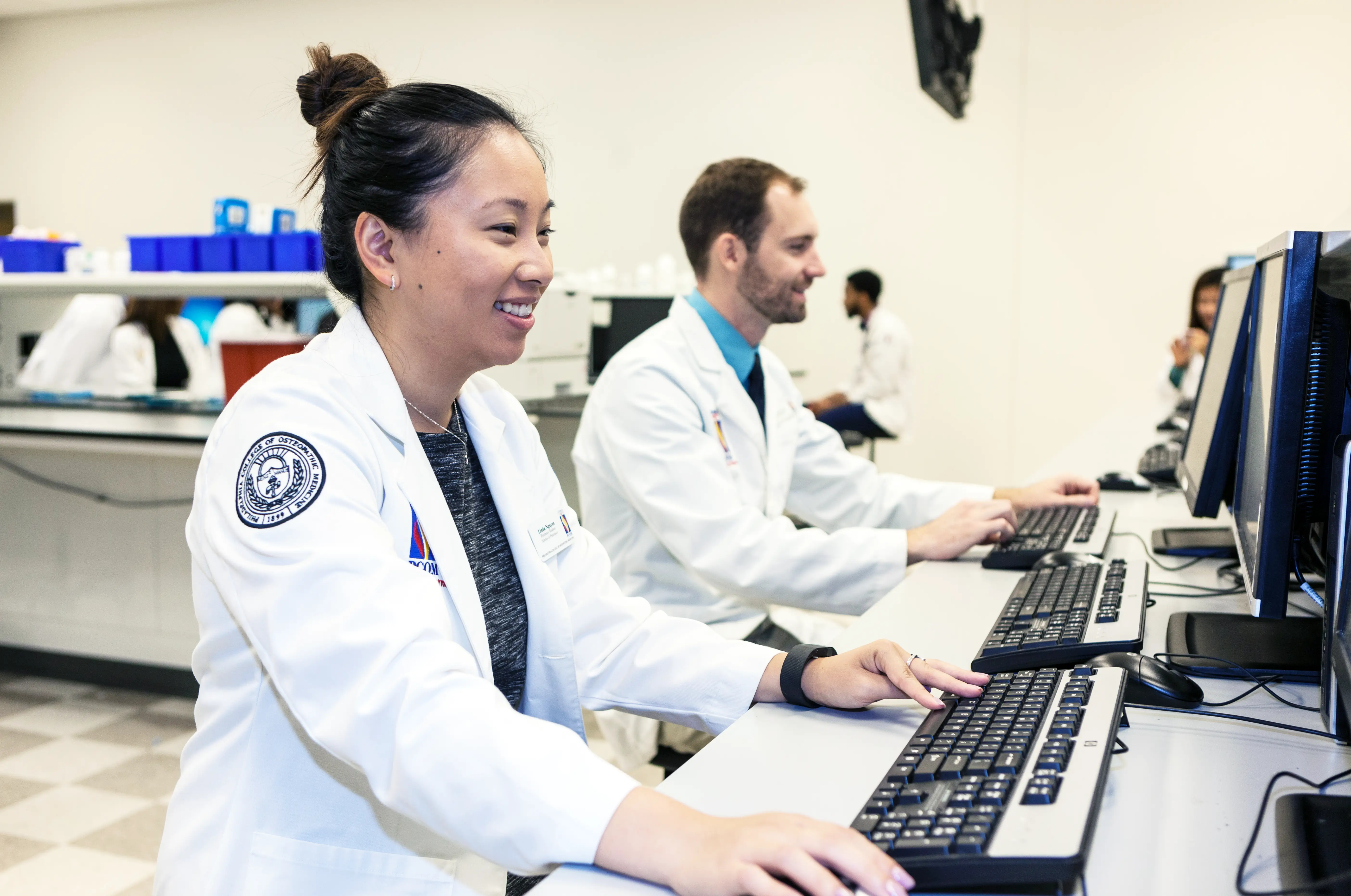 Two pharmacy students in a classroom using computers.