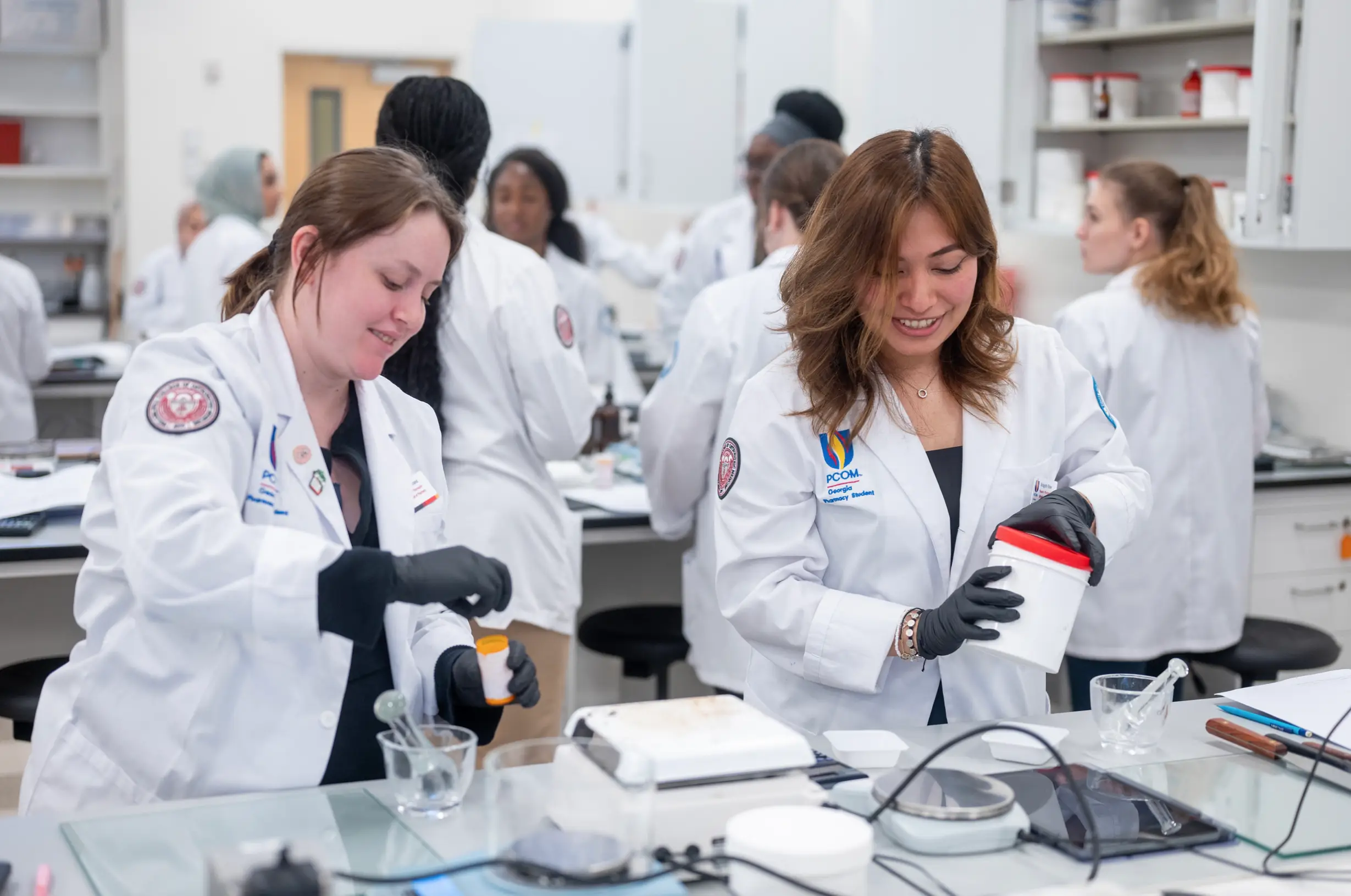 Two pharmacy students work in a lab.