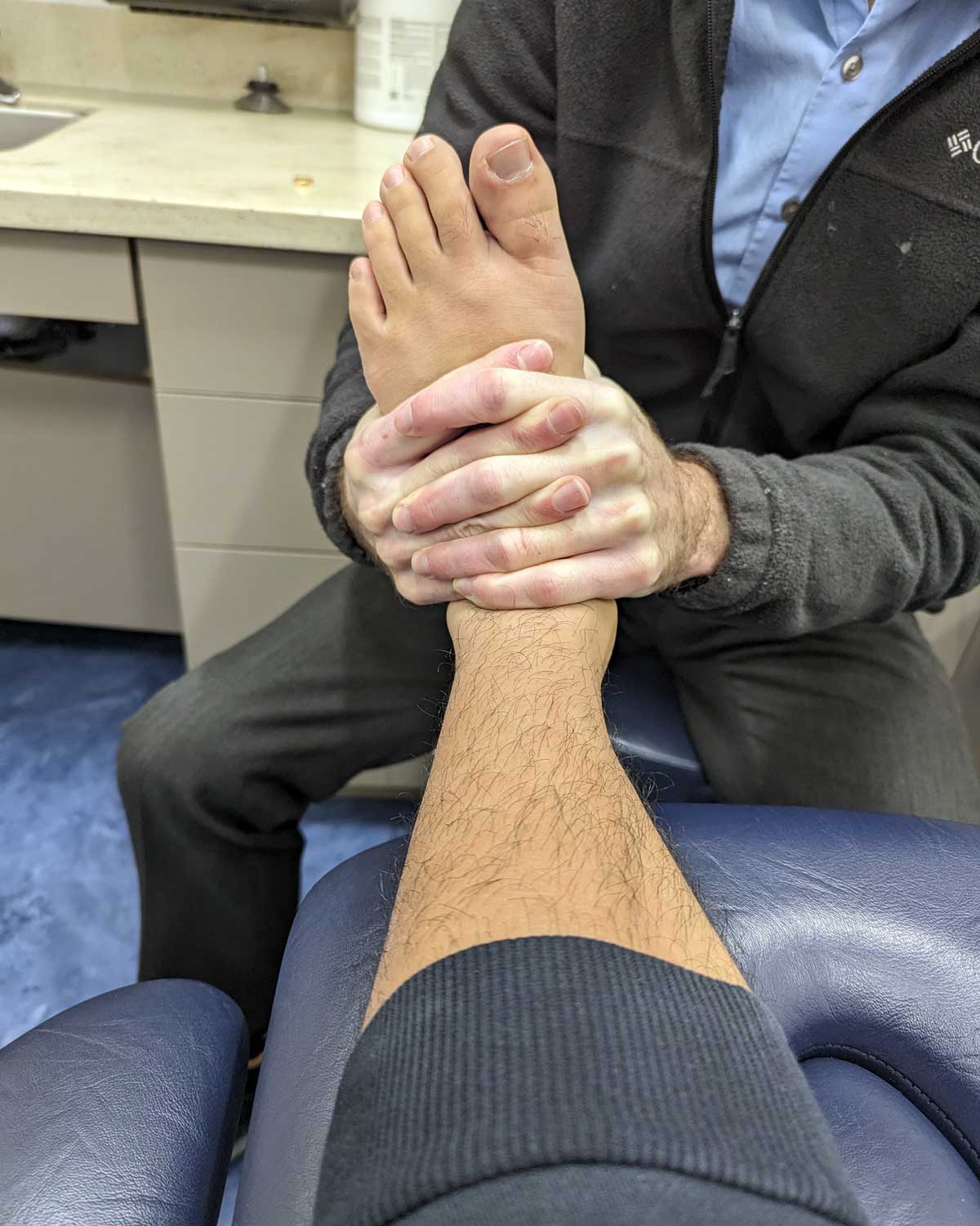 A physical therapist works to address a patient's Achilles tendon pain.