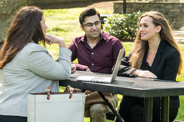 Mental health counseling students sit together at an outdoor table