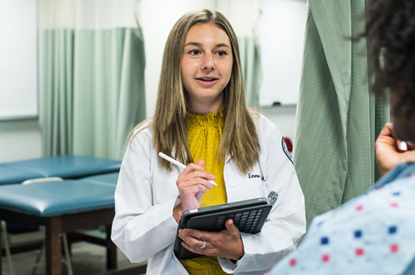 PA studies student consults with a patient during rounds