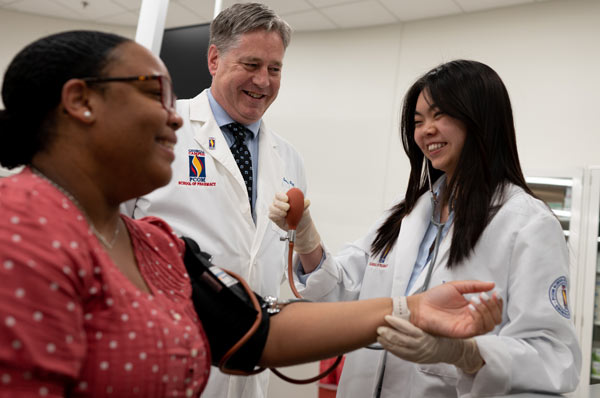 Pharmacy resident takes blood pressure of patient