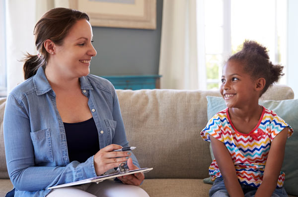 Behavior therapist sits at couch with young patient