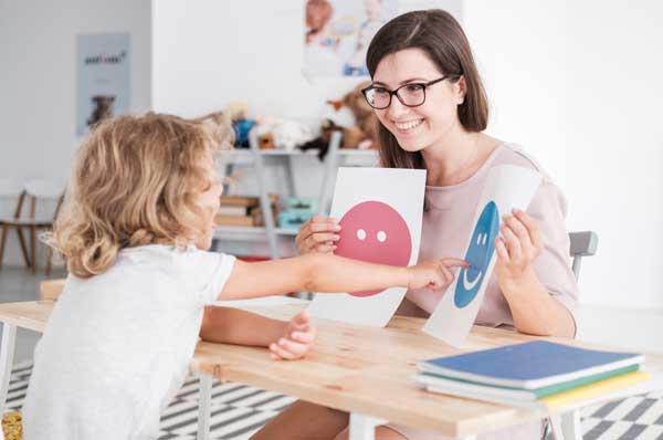 A female school psychologist works with a child.