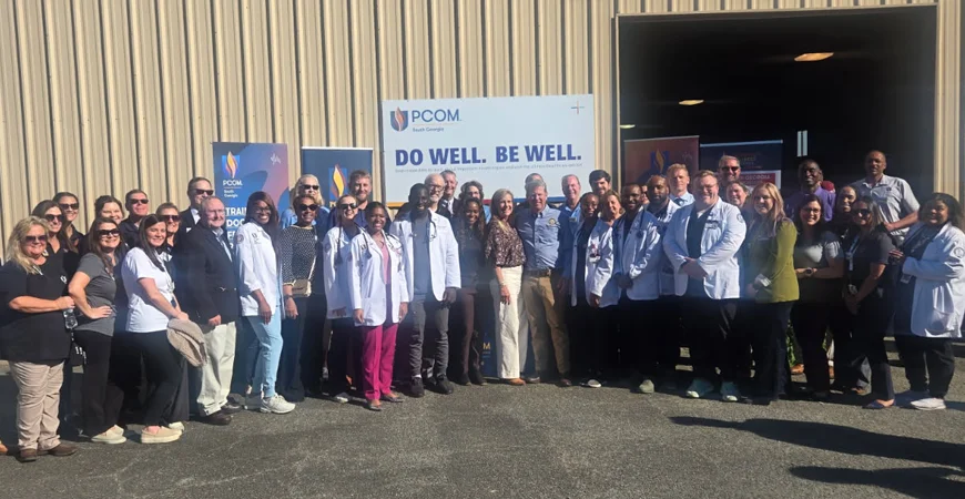 Faculty, staff and students pose together outside the PCOM South Georgia Rural Health Initiative Building at the Sunbelt Ag Expo
