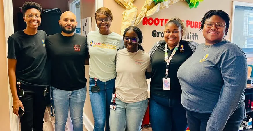 PCOM South Georgia students stand together inside office