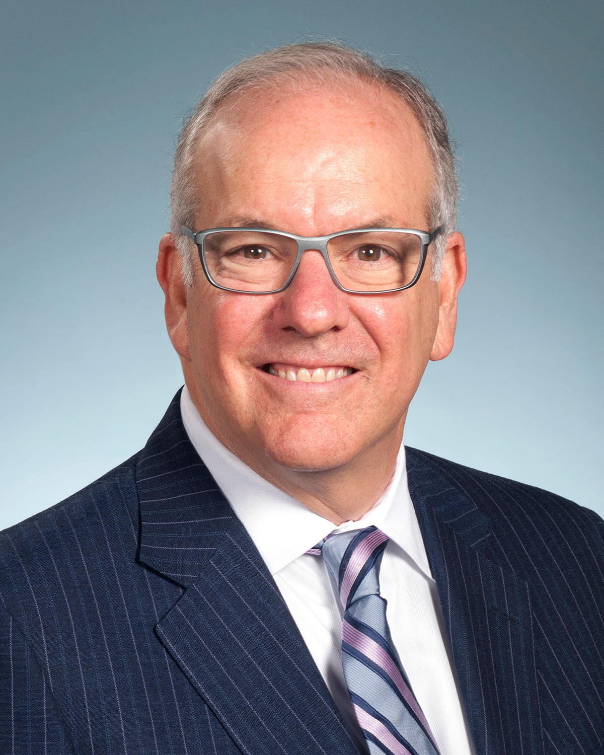 Professional headshot photograph of PCOM President and CEO Jay Feldstein, DO, wearing a suit