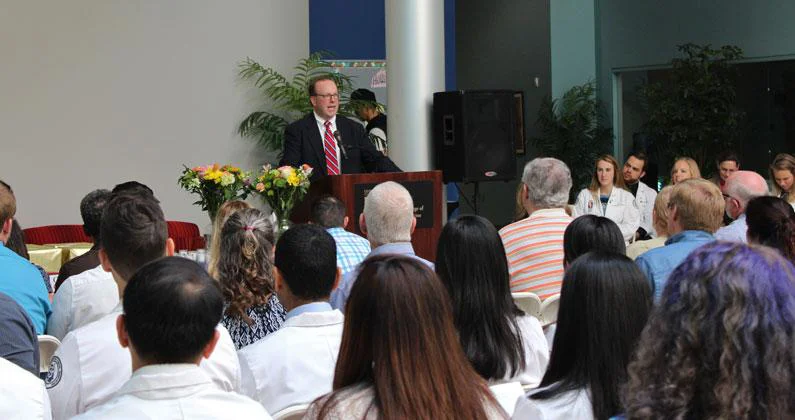 Jeffrey K. Seiple stands at podium and addresses guests. 