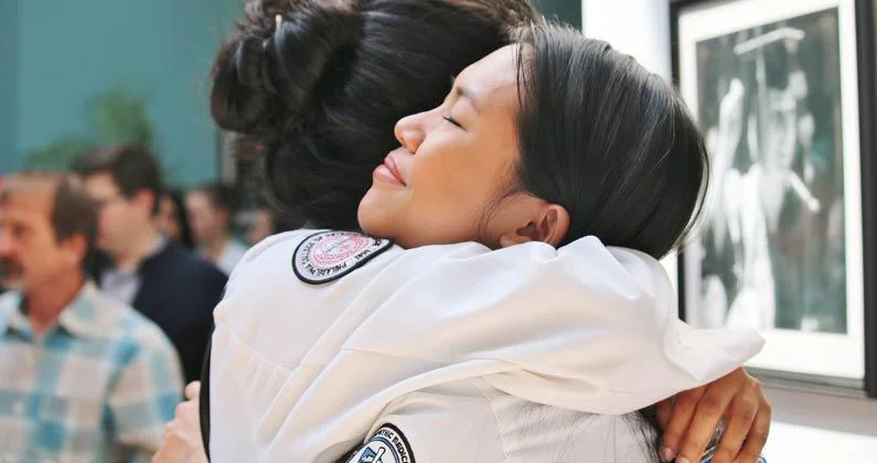A close-up photo of two PCOM Georgia students hugging. 