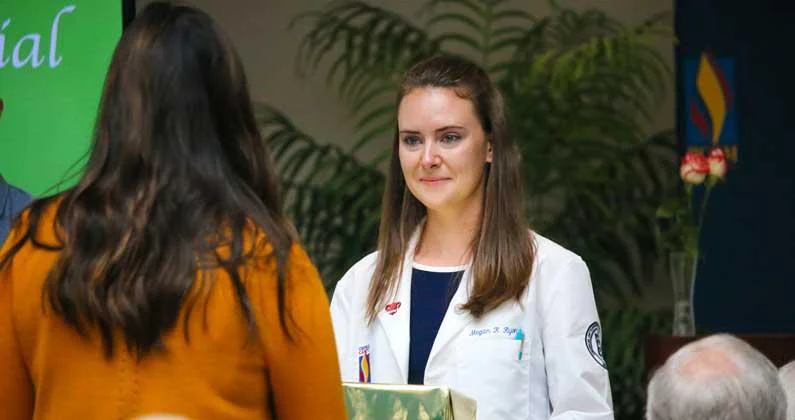A medical student hands a box to a participant