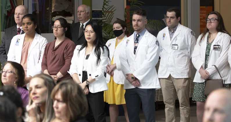 A group of PCOM Georgia students and faculty stand at the front of the room