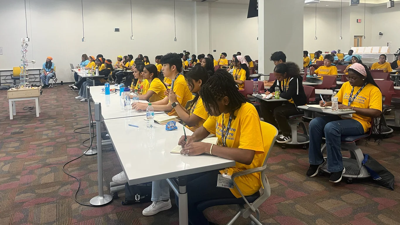 Opportunities Academy participants take notes during a lecture