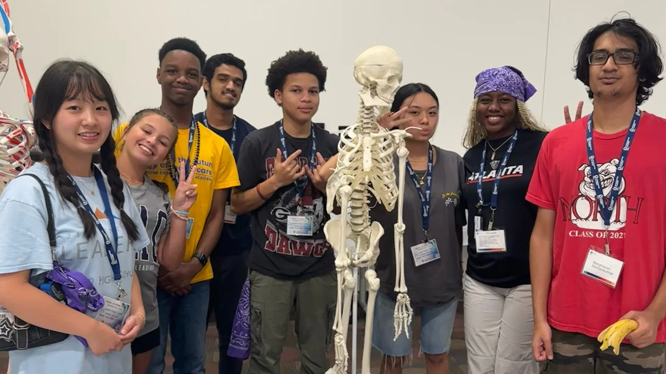 Students pose around skeleton on stand