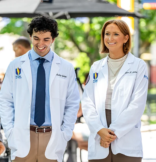 Medical students smiling while talking on a walking path outside at PCOM's Philadelphia campus
