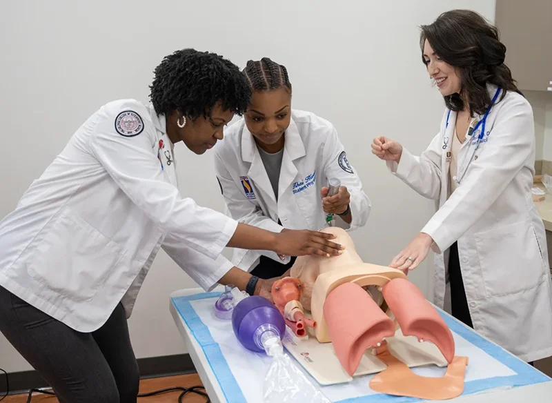 Two med students practice intubation under the guidance of a DO faculty member in PCOM Georgia's Simulation Center