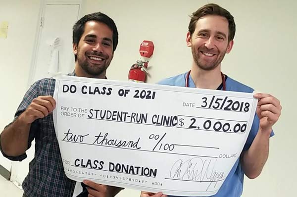 Christopher Gable (DO '18) and Adam Kardon (DO '18) hold up a fundraising check for the Student Run Homeless Clinic