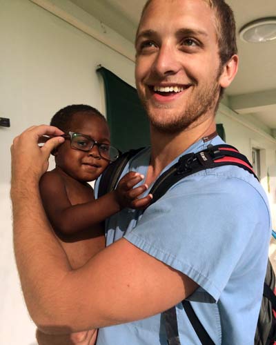 Luke King (DO '18) holding an infant during a medical mission trip to Haiti