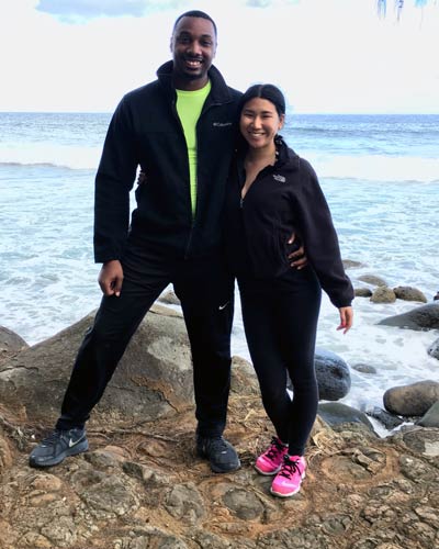 Photograph of Christina Larkin (MS/PA '18) and her husband posing during a workout along a rocky coast.