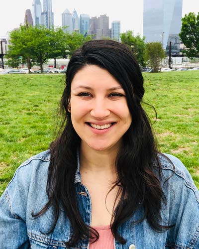 Headshot photograph of Caitlin Mede, MS/MHC '19 with the Philadelphia skyline in the background