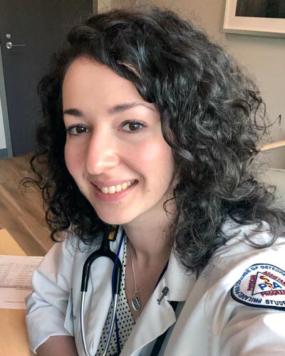 Margaryta Tolchynska (MS/PA ’19) smiling while wearing her physician assistant white coat