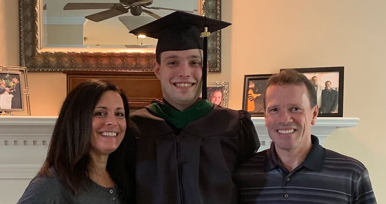 Nicholas Caputo wears his cap and gown and poses with his mother CathyJo Caputo and father Donald Caputo