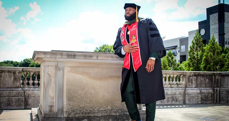 Obinna Ekechukwu, PharmD ‘20, wears his cap and gown.