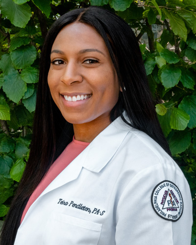 PCOM PA Studies graduate, Teira Pendleton, smiles in her white coat