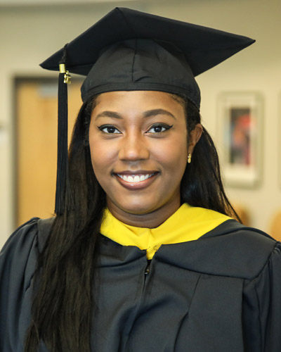 PCOM South Georgia biomed graduate adn health equity advocate Elohise St. Fort, MS, wears her cap and gown