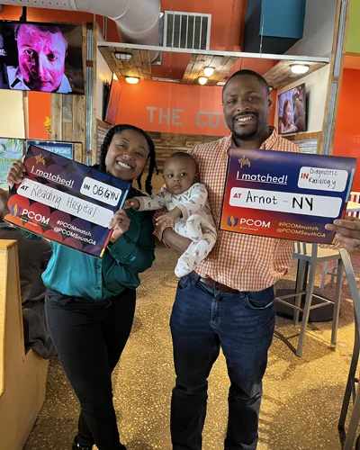 PCOM South Georgia medical students Justice and Anthony Dove pose with their infant son on Match Day 2025